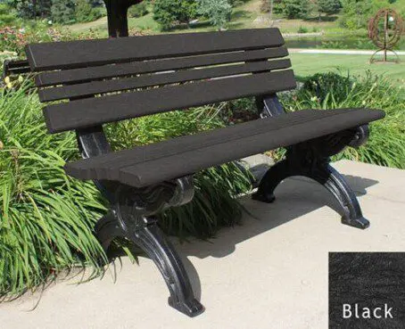The Cambridge 4 ft. recycled plastic bench is very stylish with the ornately molded black frames that look like cast metal but are made of recycled plastic. The black seat and back are made of 2"x 2" slats set between 2" x 4" bullnose edge boards. It's placed on a concrete pad in a park next to a flower bed.